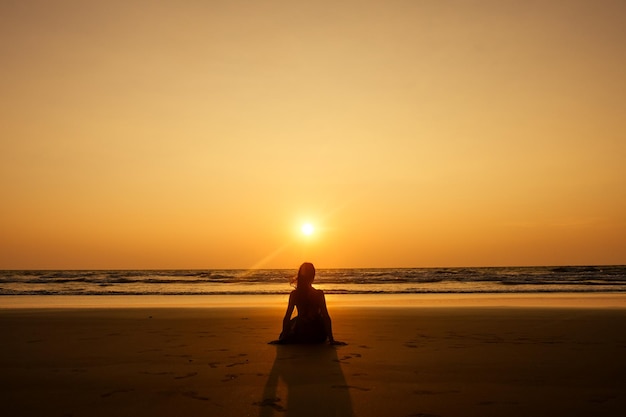 Zewnątrz młoda ładna kobieta pozuje samotnie w pobliżu morza