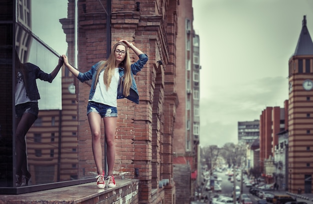 Zewnątrz portret całkiem młoda dziewczyna, ubrana w stylu grunge swag hipster na tle miejskim