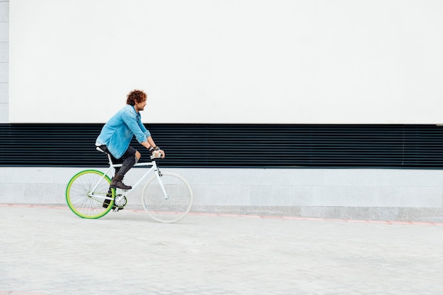 Zewnątrz portret przystojny młody człowiek z rowerem na ulicy.