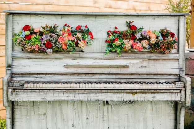 Zewnętrzne dekoracyjne retro białe pianino z kwiatowymi ornamentami i kaskadą wodną