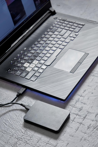 Zewnętrzny dysk twardy podłączony do laptopa, idealny do tworzenia kopii zapasowych z selektywnym naciskiem