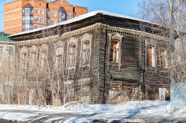 Zewnętrzny widok opuszczonego drewnianego domu zabitego deskami okien w koncepcji biedy i horroru w mieście zabytkowe domy są rozbierane, aby budować tanie kamienice, szybki biznes koncepcja pieniędzy