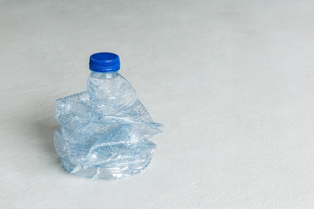 Zgnieciona niebieska plastikowa butelka