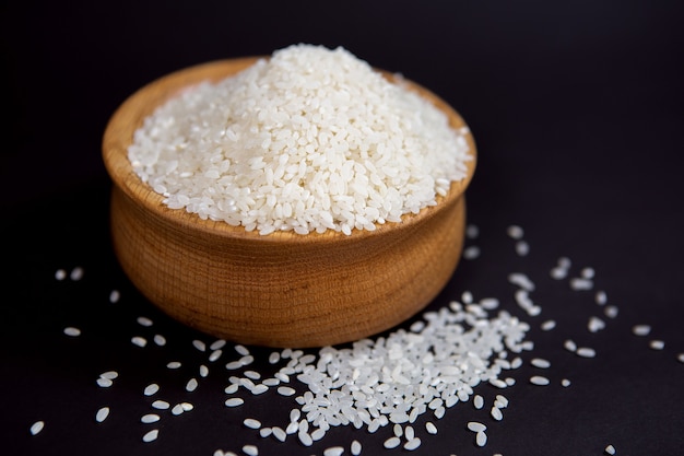 Ziarna białego ryżu w stylowej drewnianej misce