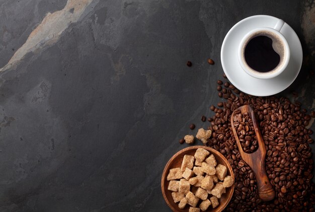 Ziarna kawy i brązowy cukier na kamiennym stole