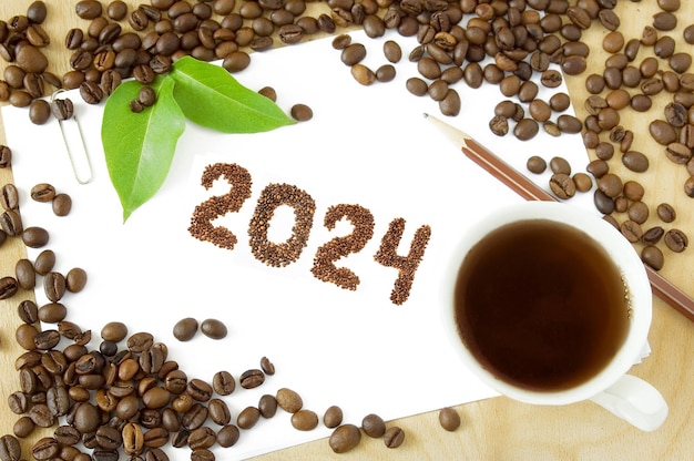 Zdjęcie ziarna kawy i liczby 2024 na białym tle wesołych świąt i szczęśliwego nowego roku 2024