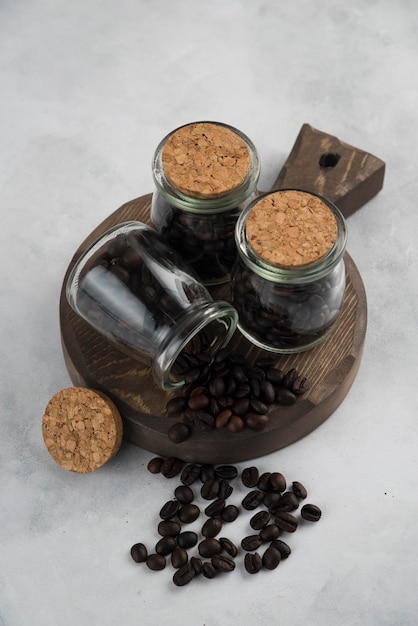 Ziarna kawy w butelce na drewnianym talerzu