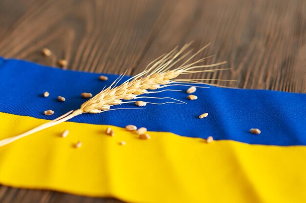 Zdjęcie ziarna pszenicy z żółto-niebieską ukraińską flagą na drewnianym tle