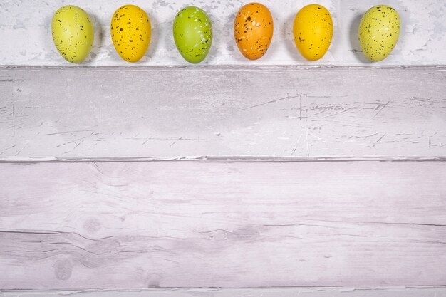 Zieleni I Pomarańczowi żółci Easter Jajka Na Tle Stare Drewniane Deski Przypominają Starego Parkietowego. Wielkanocna Koncepcja