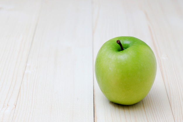 Zielona jabłczana owoc na drewnianym tle