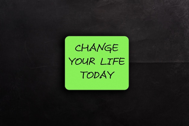 Zielona karta ze słowami zmienia twoje życie na czarnym tle