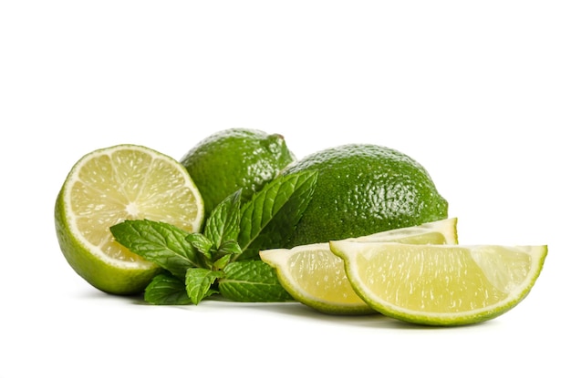 Zielona mięta dwie limonki i dwa plasterki soczystej limonki izolowane na białym tle