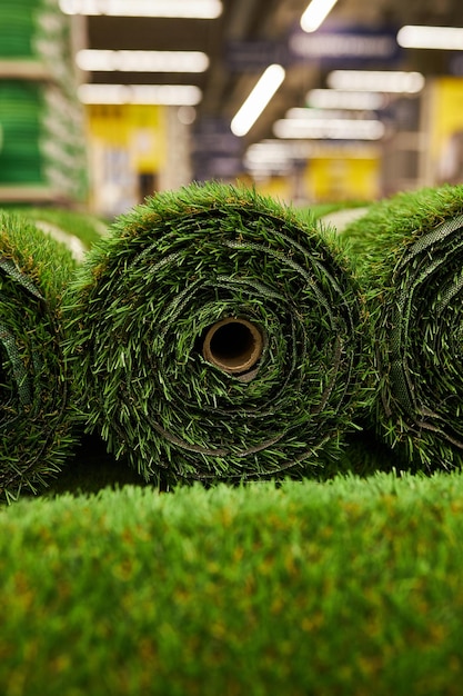 zielona sztuczna trawa w rolkach z bliska Rolki sztucznej trawy w magazynie materiałów budowlanych
