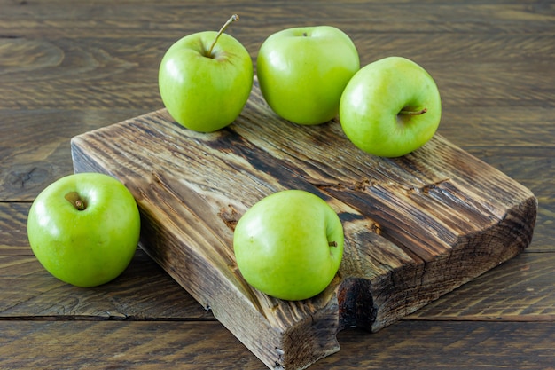 Zielone dojrzałe jabłka na drewnianym biurku. Styl rustykalny. rolnictwo przyjazne dla środowiska. zrównoważona żywność.