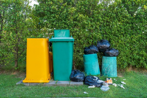 Zielone i żółte kosze na śmieci w ogrodzie
