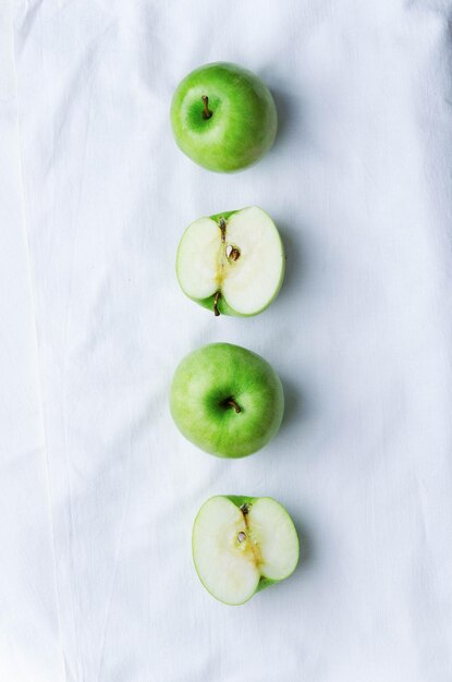 Zielone jabłka na białym obrusie nad widokiem