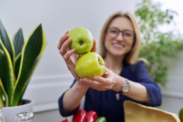 Zielone jabłka w rękach kobiety dietetyka zdrowego odżywiania