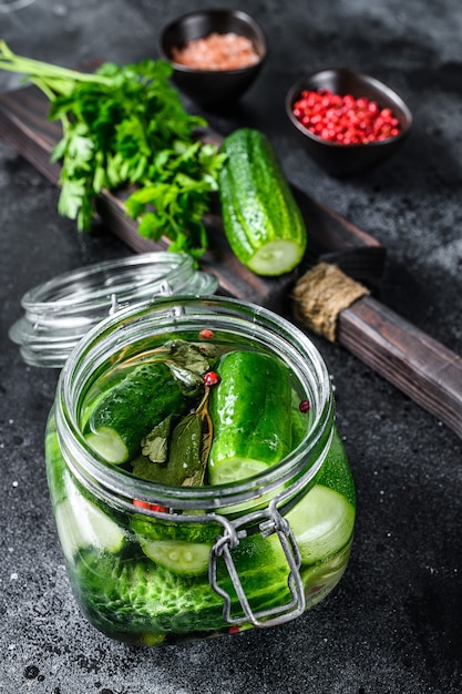 Zdjęcie zielone ogórki kiszone w szklanym słoju. naturalny produkt. widok z góry.