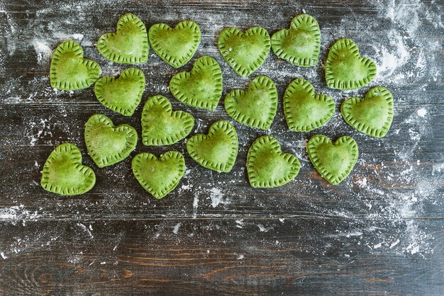 Zielone Ravioli w kształcie serca na drewnianej powierzchni