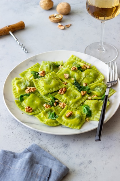 Zielone ravioli z serem ricotta, szpinakiem i orzechami. Zdrowe odżywianie. Jedzenie wegetariańskie. Kuchnia włoska.