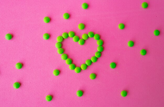 Zielone tabletki i tabletki w kształcie serca, tabletki z podszewką na serce dla kardiologii choroby serca, prebiotyki i suplementy probiotyczne dla zdrowia jelit, koncepcji farmacji i szpitala