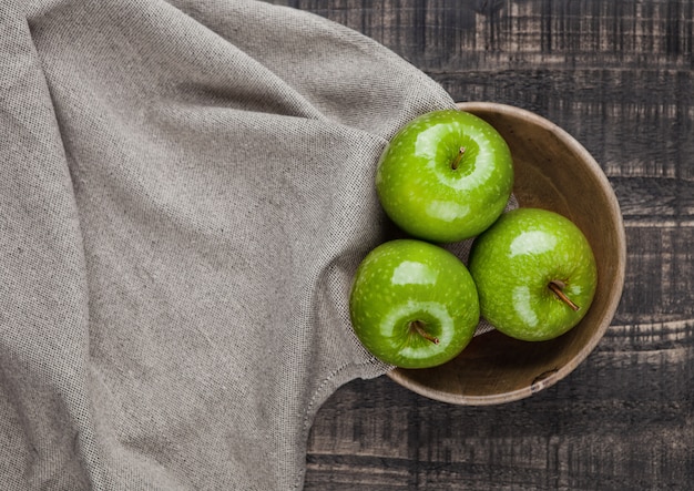 Zielone zdrowe jabłka w drewnianej misce