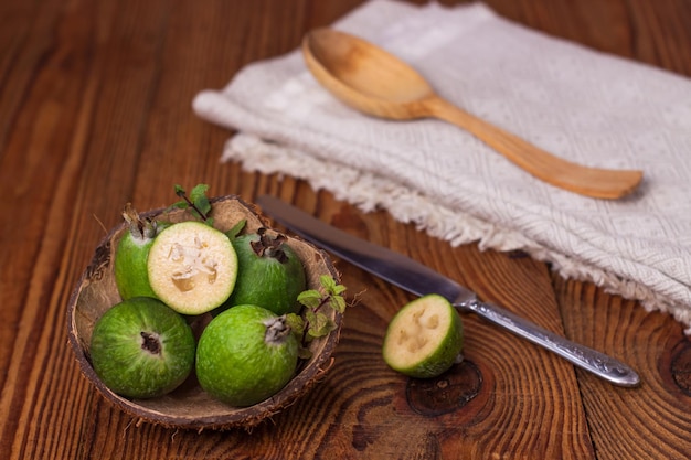 Zielony feijoa w łupinie orzecha kokosowego na drewnianym tle Dojrzałe owoce tropikalne surowe wegańskie jedzenieWitamina C Skopiuj miejsce