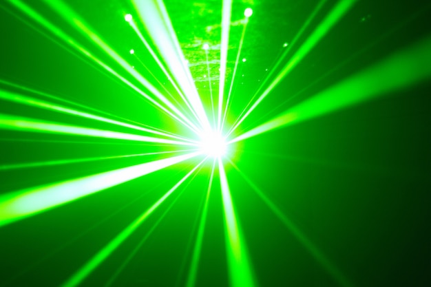 Zielony i czerwony laser w klubie nocnym. Wiązki laserowe na ciemnym tle, klubowa atmosfera