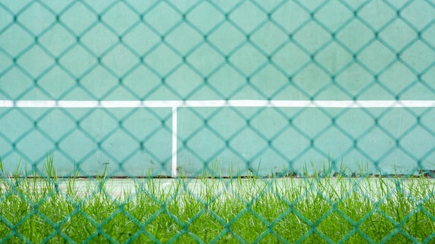 Zielony kort tenisowy i ściana do ćwiczeń - tylna zielona metalowa klatka