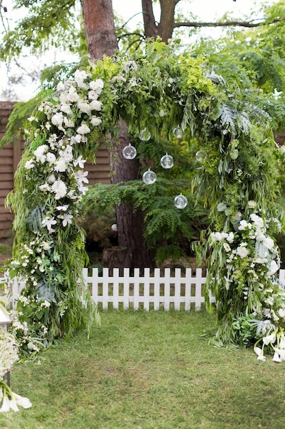 Zielony ogrodowy łuk ślubny z kwiatami