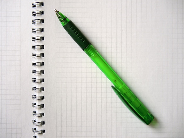 Zielony ołówek na otwartym spiralnym notatniku