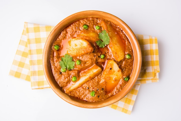 Ziemniaczane curry lub smażone aloo lub aaloo masala z zielonym groszkiem, indyjskie danie główne, selektywne skupienie