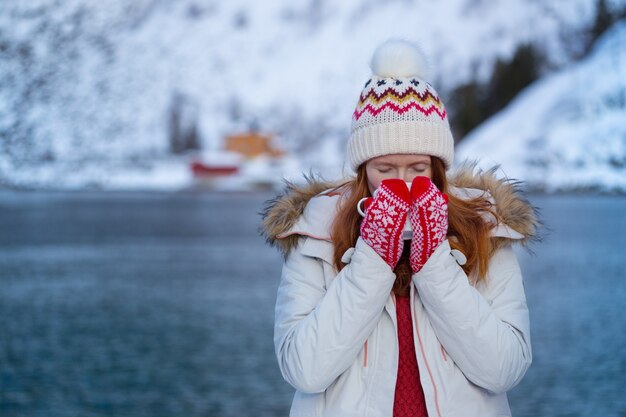 Zima. dziewczyna z filiżanką na tle rorbu na Lofotach. Norwegia