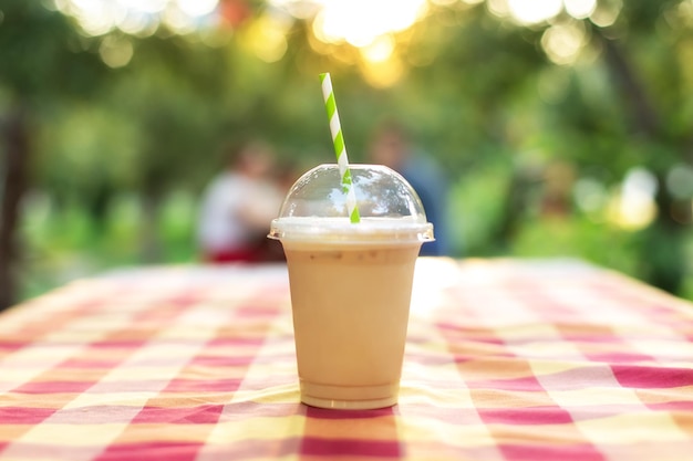 Zimna mrożona kawa z mlekiem na stole w ulicznej kawiarni letni napój w ogrodzie