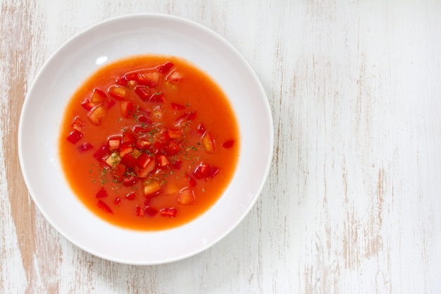 Zimna zupa pomidorowa w białej drewnianej powierzchni