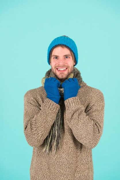 Zimne dni, ciepłe serca. Szczęśliwy człowiek czuje ducha wakacji. Mężczyzna nosi ubrania zimowe w chłodne dni. Przytulne zimowe życzenia. Wesołych świąt.