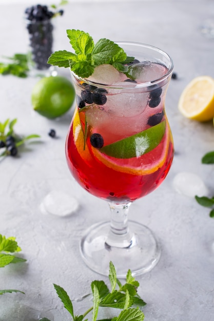 Zimne letnie domowe lemoniady z owoców i jagód. Mojito, lemoniada lub sangria w szkle.