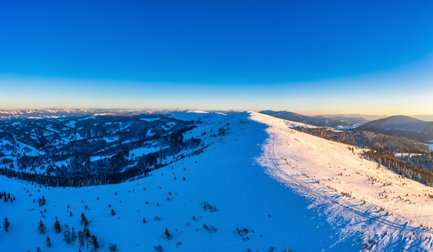 zimowa panorama zaśnieżonych stoków w ośrodku narciarskim w Europie w słoneczny, bezwietrzny mroźny dzień