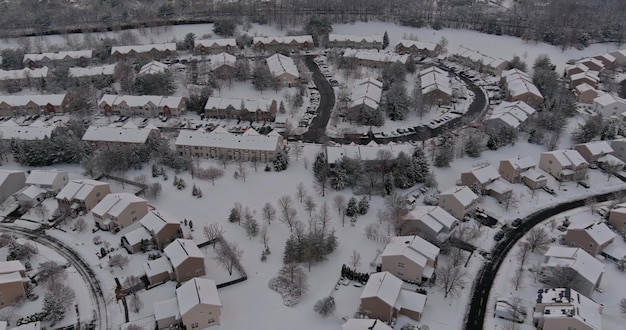 Zimowa sceneria dachowa domy zaśnieżone mieszkalne małe miasteczko podczas zimowego dnia po opadach śniegu z anteny