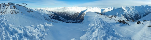 Zimowa sceneria górska ze stacją narciarską na ośnieżonych stokach (Tyrol, Austria). Panorama.