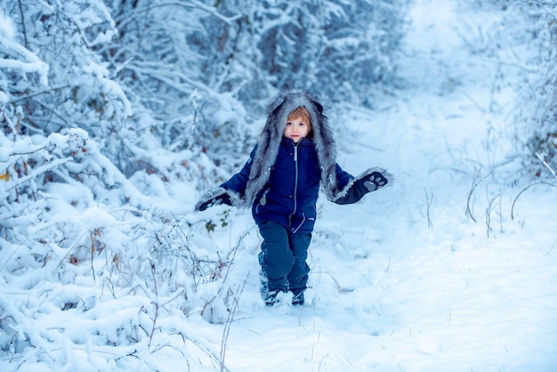 Zimowe dziecko pozuje i dobrze się bawi, ciesząc się zimą