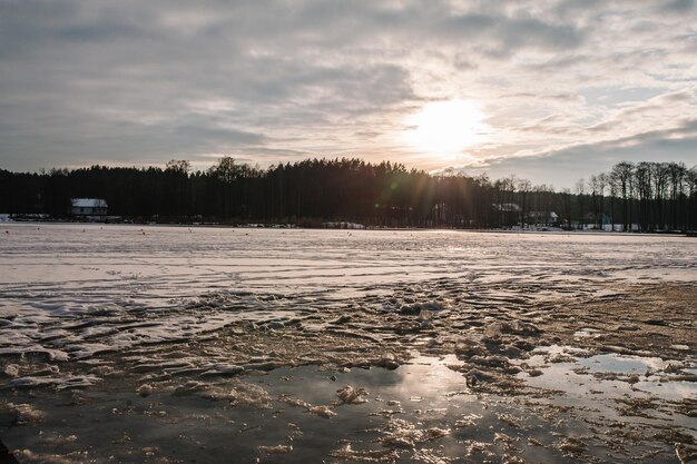 Zimowe łowienie szczupaków na imitacje ryb na zamarzniętym jeziorze Wiele małych sprzętów do łowienia zimą na lodowym stawie Śnieg zimą na jeziorze o wschodzie słońca