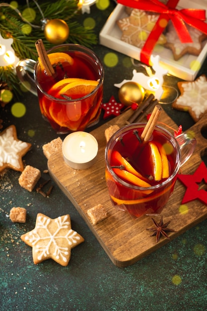 Zimowe świąteczne grzane wino z pomarańczą i przyprawami na świątecznym stole. Skopiuj miejsce.