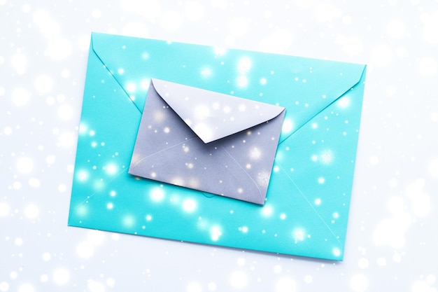Zimowe wakacje puste papierowe koperty na marmurze z błyszczącym śniegiem flatlay tle list miłosny lub świąteczna kartka pocztowa