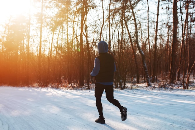 Zimowy bieg Młody wysportowany mężczyzna biegający w parku Sport Styl życia Poranek
