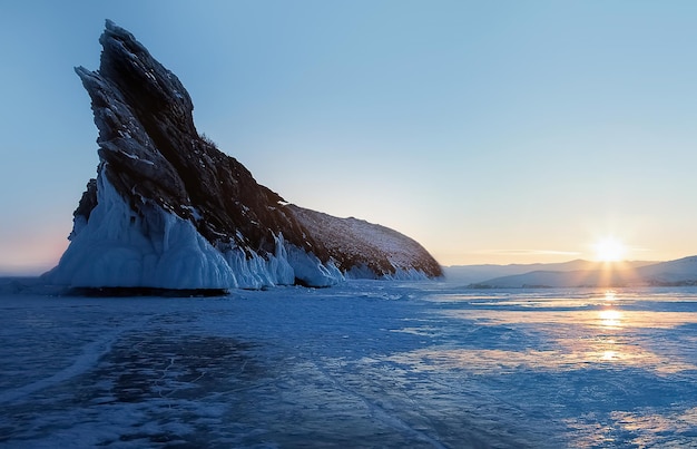 Zimowy krajobraz nad jeziorem Bajkał Promienie wschodzącego słońca na tle ogromnej skały