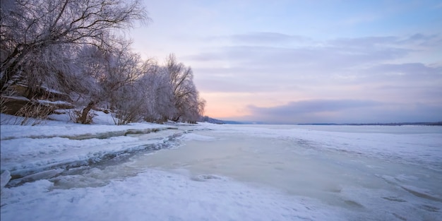 Zimowy krajobraz o świcie, brzeg zamarzniętego lodu.