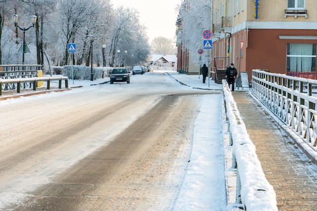 Zimowy krajobraz w mieście o zachodzie słońca Pusta droga pokryta śniegiem i lodem Spacer po mieście w mroźną pogodę