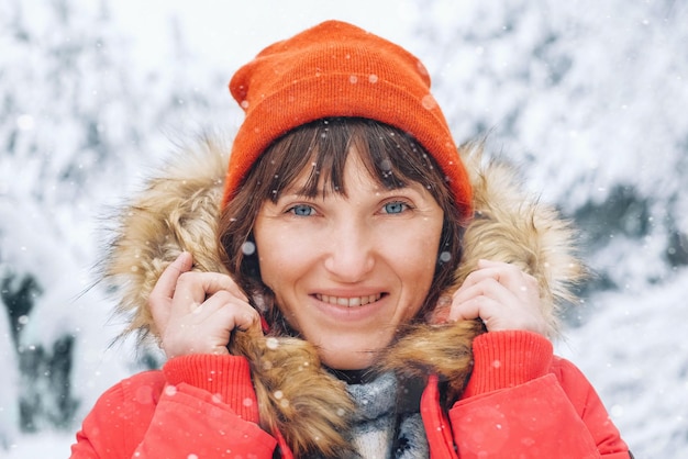 Zimowy portret kobiety w czerwonych ubraniach na tle ośnieżonych drzew