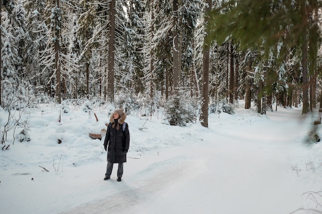 Zimowy spacer po lesie pokrytym śniegiem pięknym sosnowym lasem